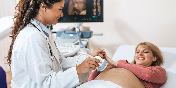 Médica realiza ultrassonografia em paciente gestante