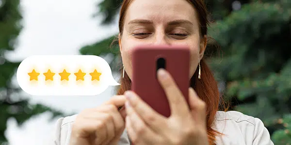 Mulher fazendo avaliação 5 estrelas no celular