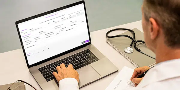 Médico com o computador em aba aberta na emissão de nota fiscal do sistema Amplimed