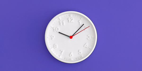 Relógio branco de ponteiros em parede roxa marcando dez horas e sete minutos