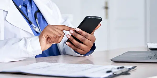 Médica utilizando prontuário eletrônico por dispositivo móvel.