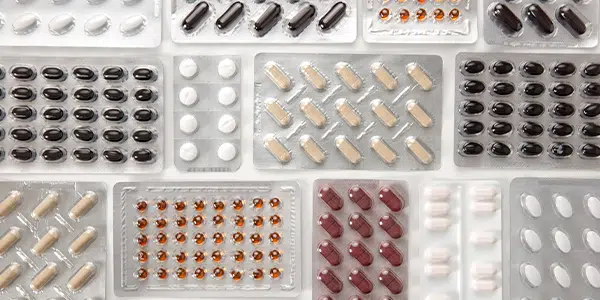 Diversas cartelas de remédios em cima da mesa.