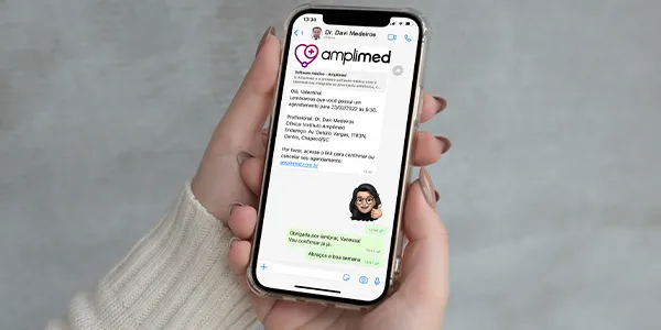 Pessoa com celular na mão, recebendo confirmação de consulta por meio do agendamento online da Amplimed