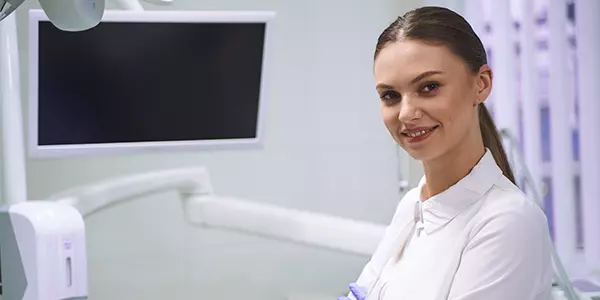 médica posa em frente a monitor