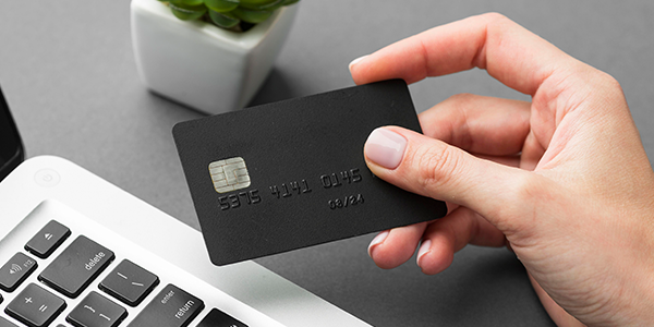 Detalhe de mão segurando cartão de crédito