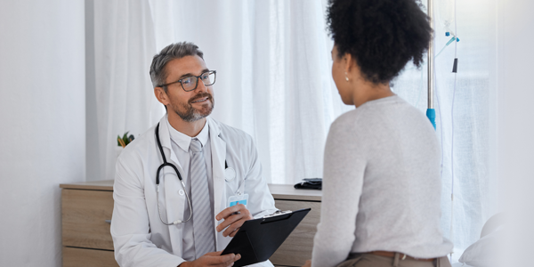 Médico com prancheta na mão em consulta com paciente