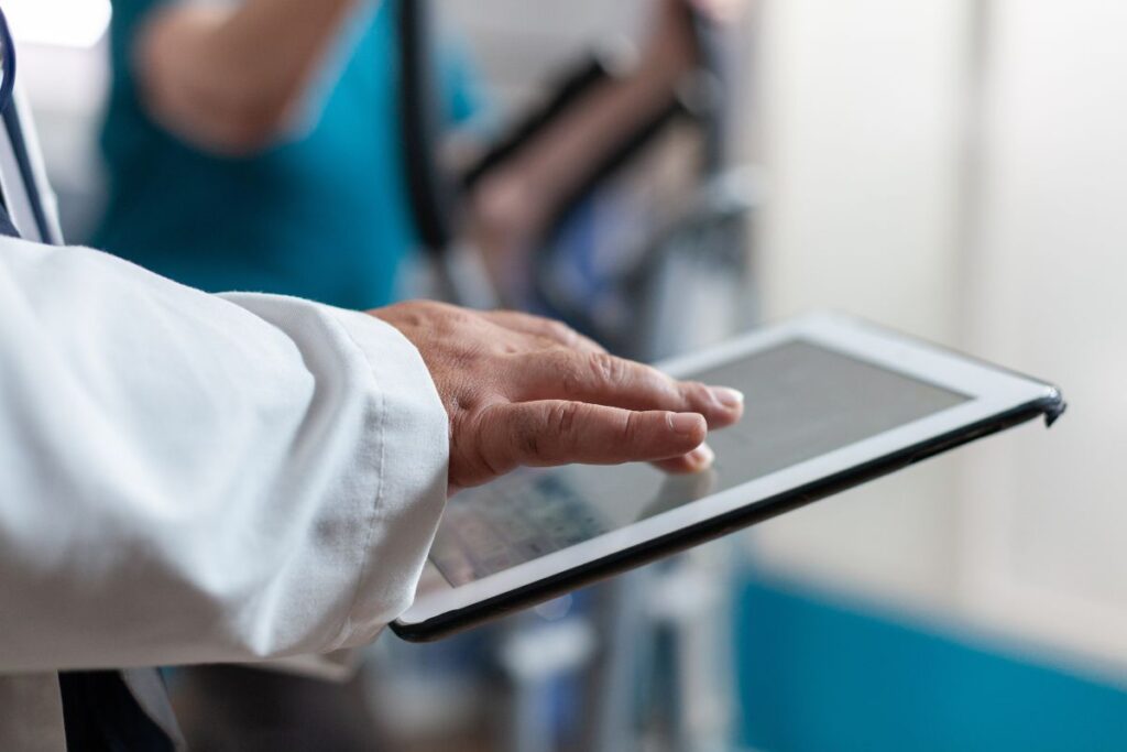 Médico utilizando tablet com prontuário digital otimizado por IA para médicos