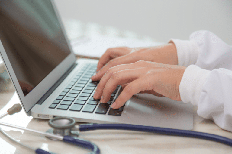 Mãos em notebook e estetoscópio, alusão ao valor da Amplimed