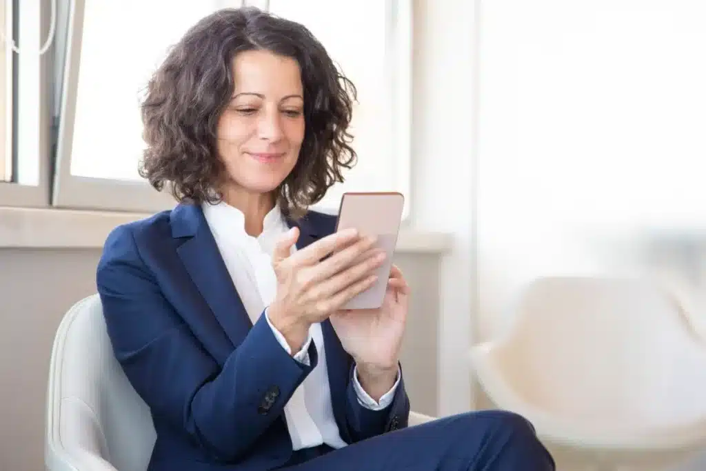 Terapeuta usando celular, ilustrando como um psicólogo emite nota fiscal