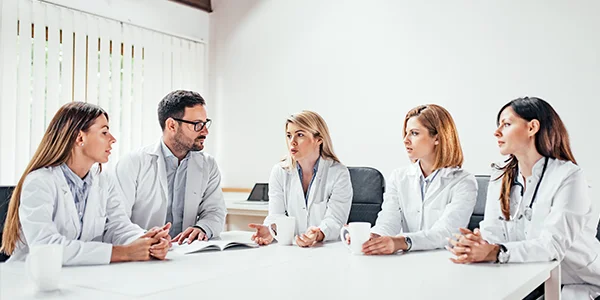 medicos-conversando-ao-redor-de-uma-mesa